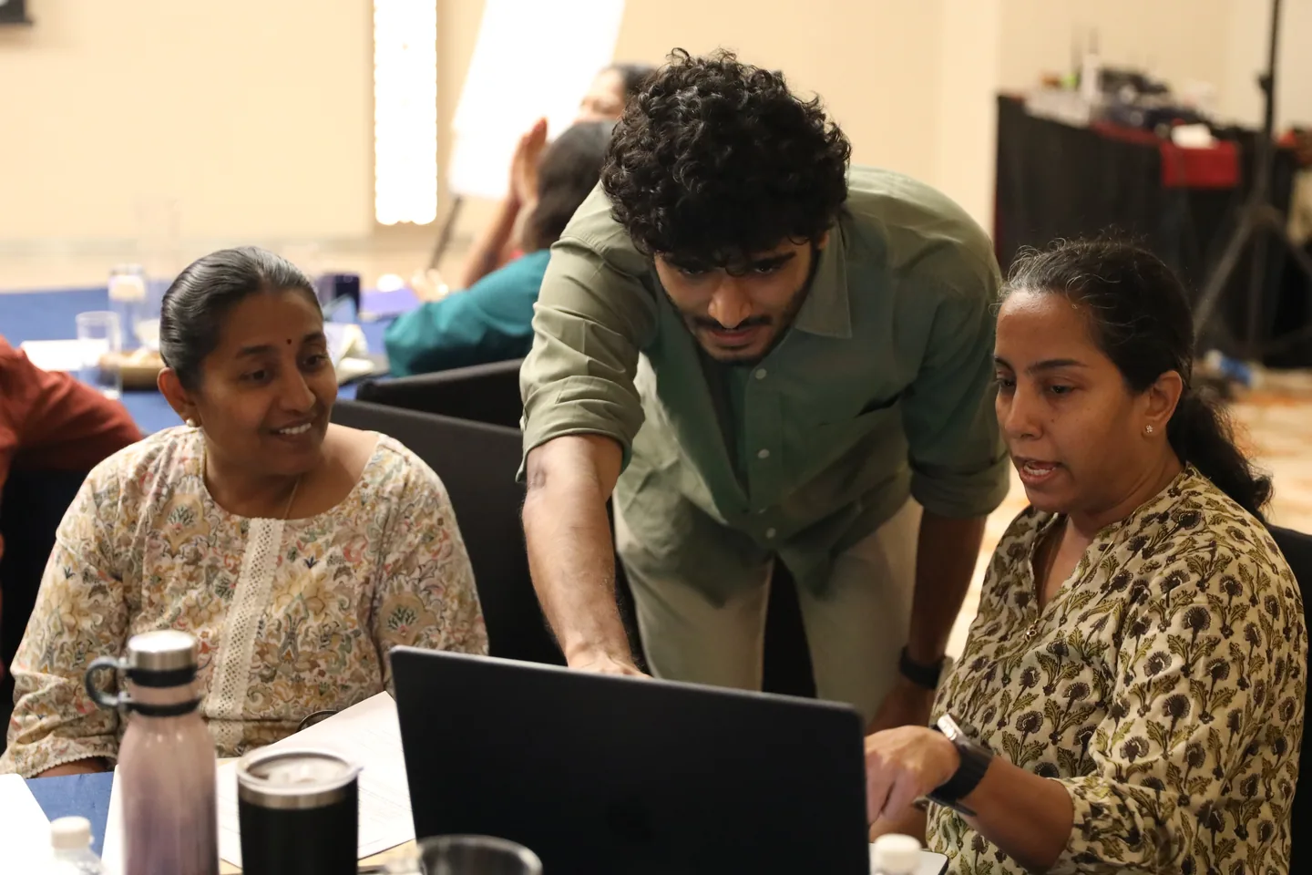 A Dalgo team member helping two nonprofit colleagues work through their data on a laptop